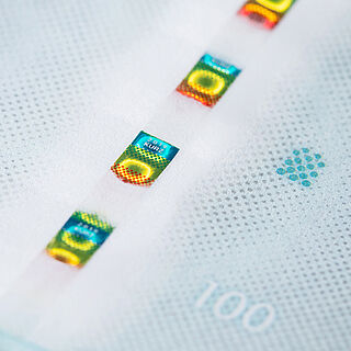 Close-up of a security thread sample with a multi-colored square-shaped FLUX movement effect
