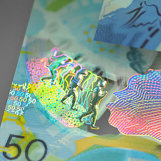 Close-up of a security feature showing a 3D motif of a walking man