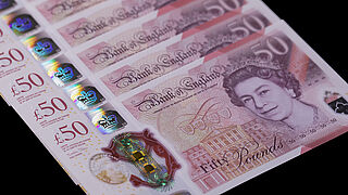 Close-up of multiple 50 English pound banknotes with a KINEGRAM COLORS® security feature