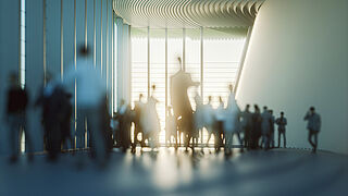 Image of groups of people moving through a large convention hall