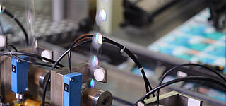 Close-up of a foil stripe running through a foil application machine