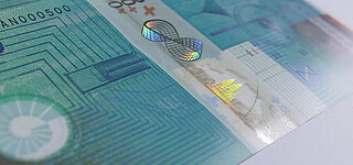 High Precision: Partially metallized KINEGRAM ZERO.ZERO® Stripe over Window on Orell Füssli's Anniversary Note Close-up of a finely detailed, partially metallized, KINEGRAM ZERO.ZERO® Stripe over Window